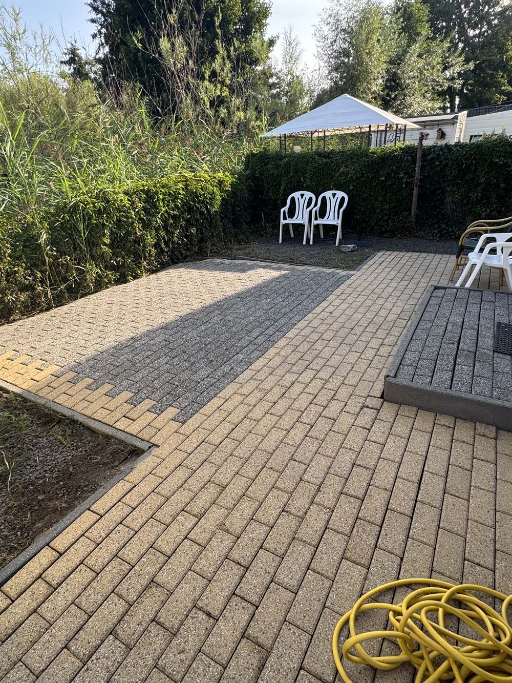 Terras in de achtertuin na reiniging door PureTerra — originele kleur van de tegels terug