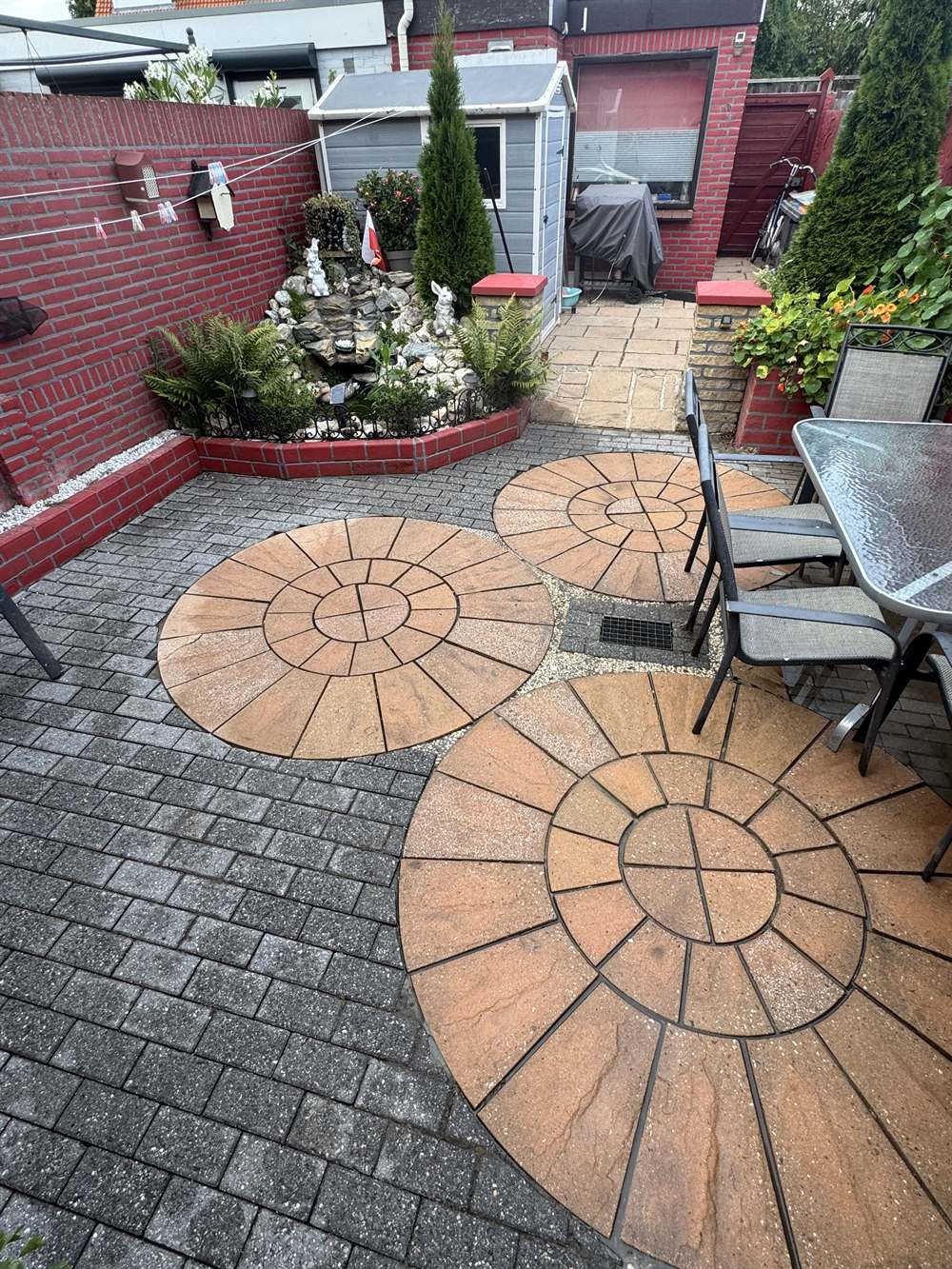 Sierbestrating met cirkelmotief na reiniging door PureTerra — warme terracotta kleur weer terug