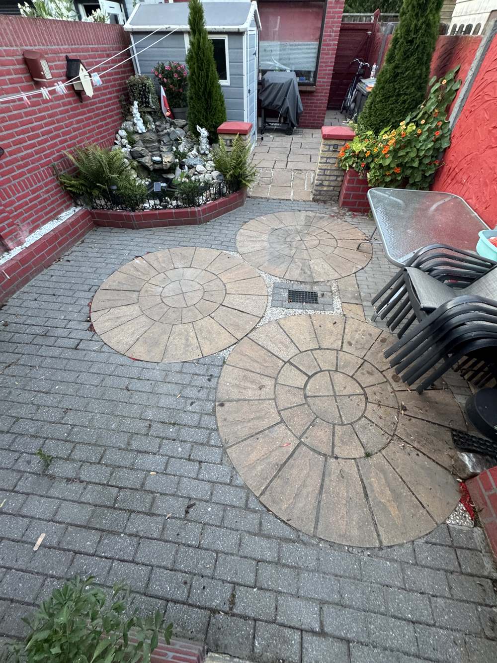 Sierbestrating met cirkelmotief vóór reiniging — dof en vergrijsd door aanslag